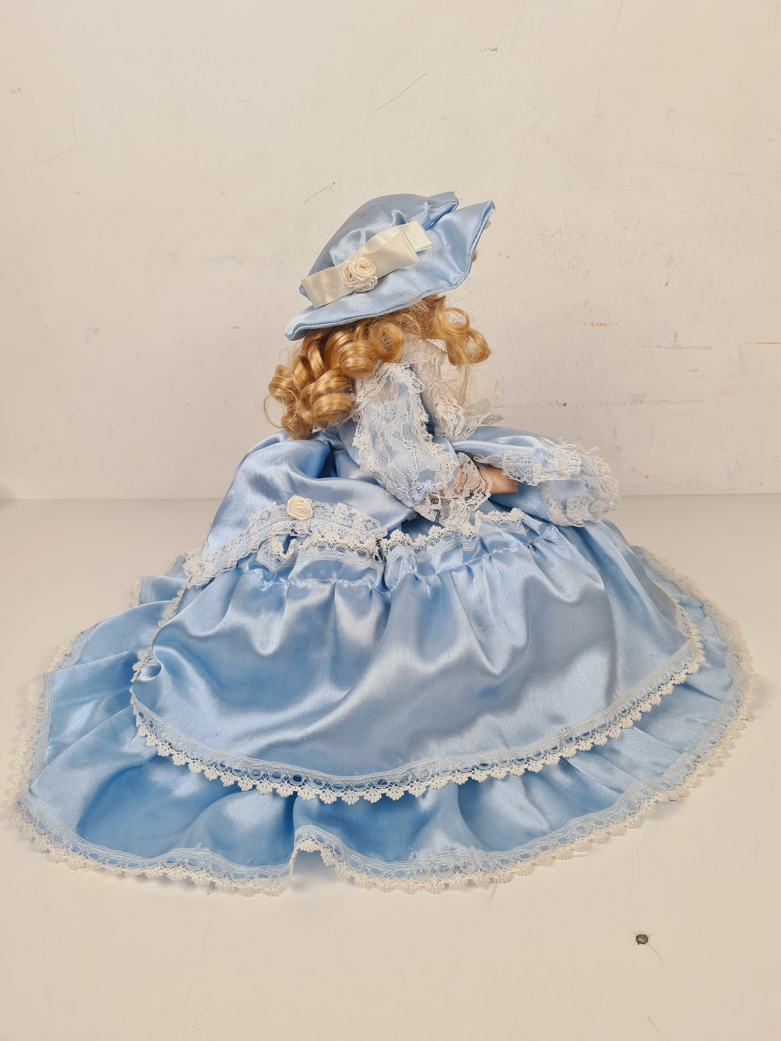 Voir photo 4 de Poupée - Poupée en porcelaine sur coussin avec une robe bleu - 33 cm Poupée - Poupée en porcelaine sur coussin avec une robe bleu - 33 cm Bon état - Vue 4 -